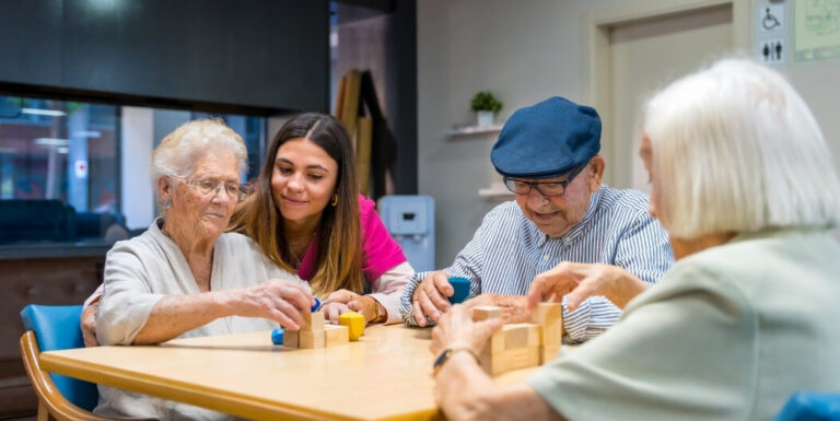 Nursing Staff Assisting Elderly Residents with Cognitive Block Activities at a Memory Care Facility