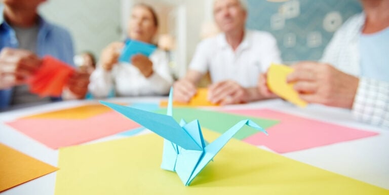 Elderly Residents Making Paper Crane Crafts at Assisted Living Facility